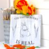The Easter Bunny is real sign with carrots and yellow daffodils