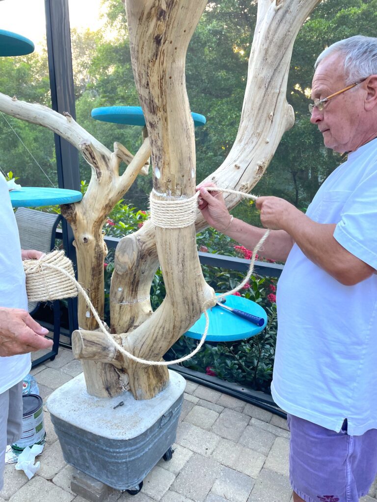Winding sisal rope around the DIY cat tree that looks like a tree