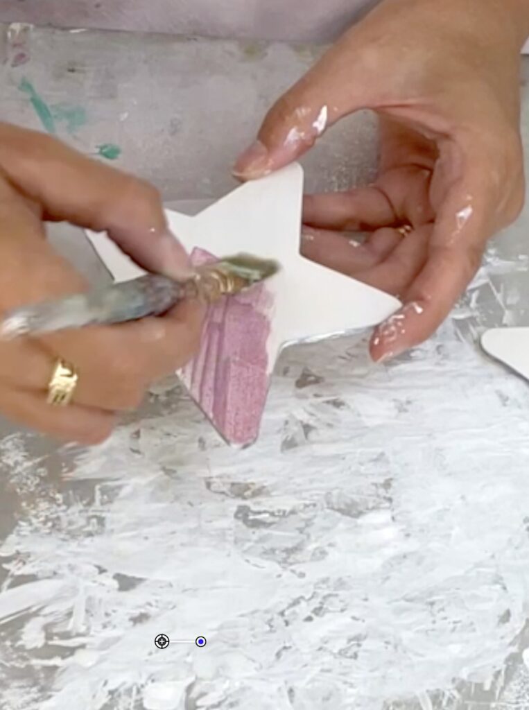 Painting wood stars with Plaid Extreme Glitter paint in red for the Fourth of July celebration centerpiece