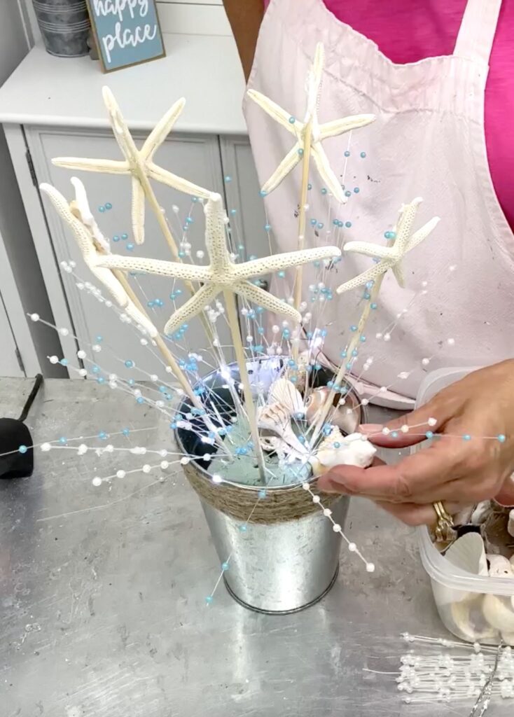 Hot gluing seashells to the bridal shower centerpiece