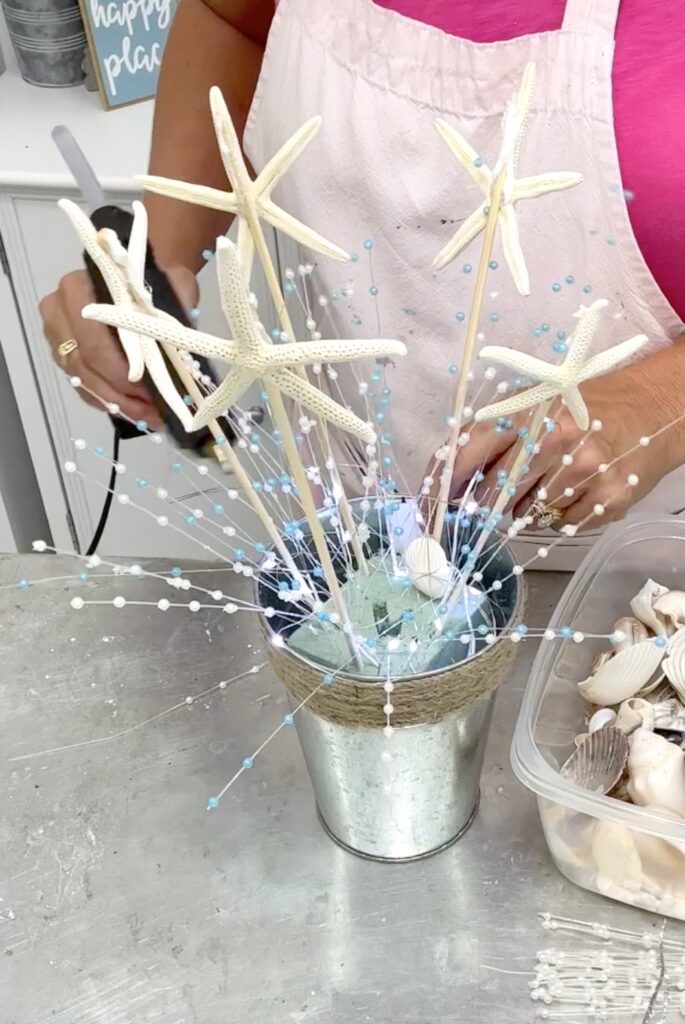 adding pearl picks to the beach bridal shower centerpiece