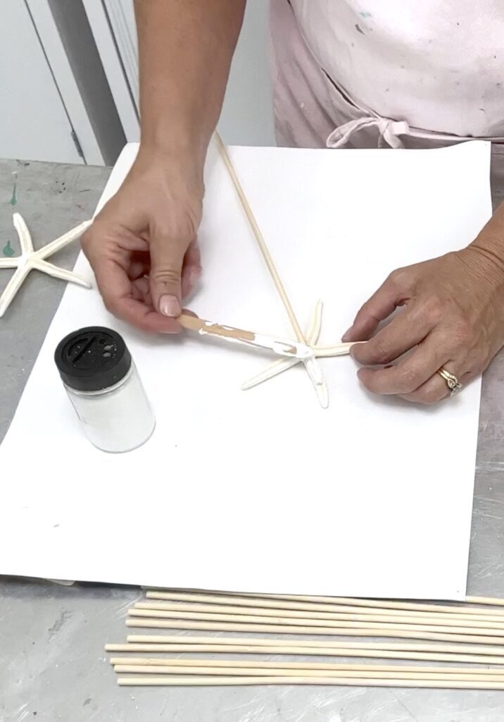 gluing starfish onto a skewer stick