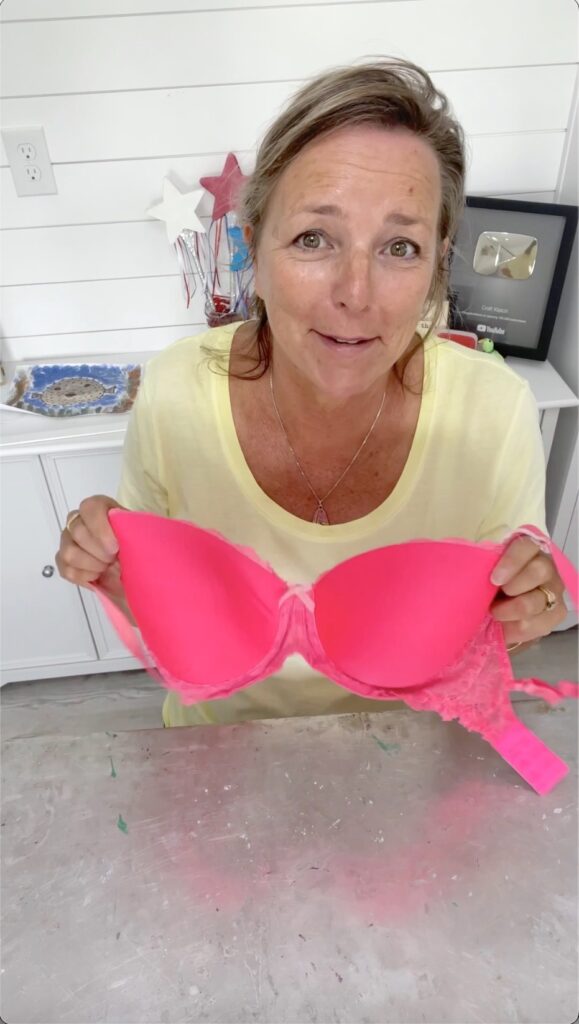 Mona holding hot pink bra for bridal shower bra pong game