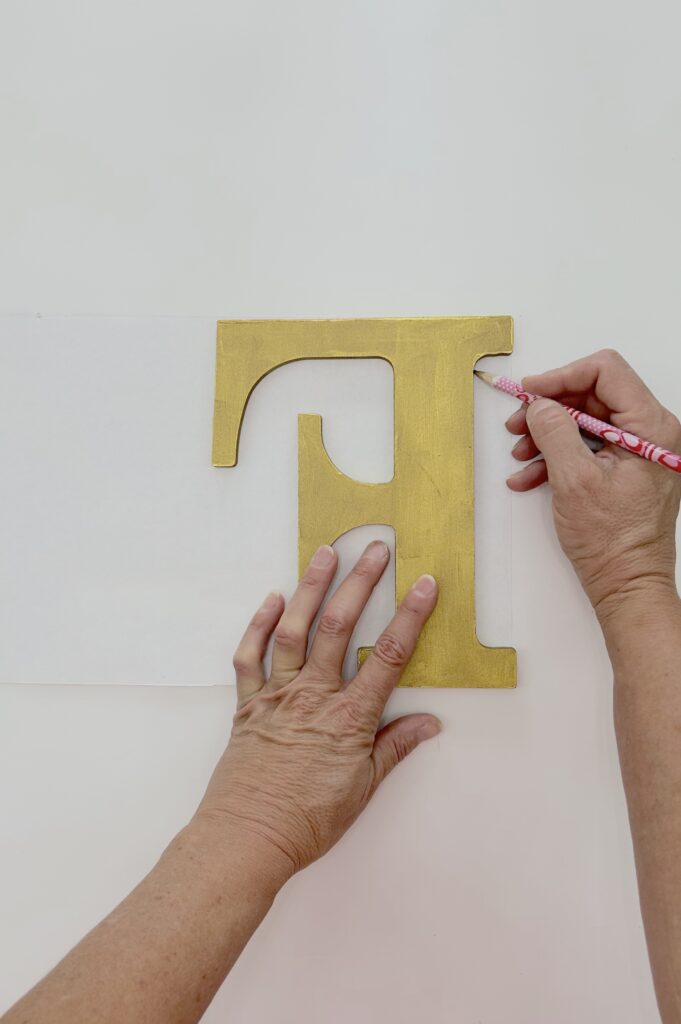 Tracing the letter F on the back of the image making sure to flip the letter backwards