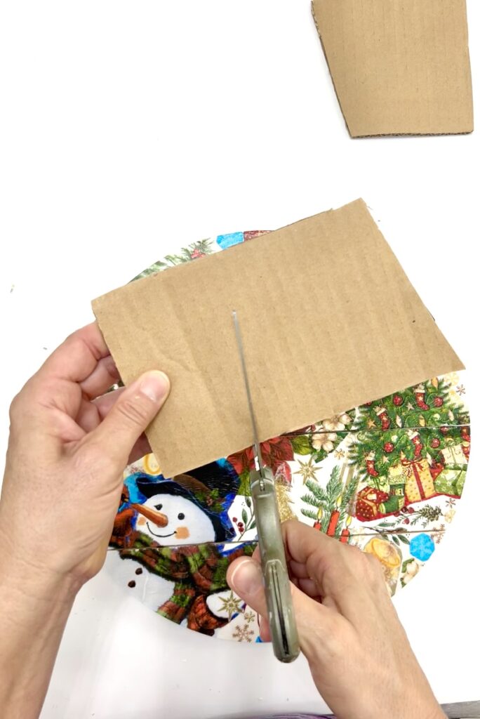 Cutting out a snowman Christmas napkin to decoupage onto ornament