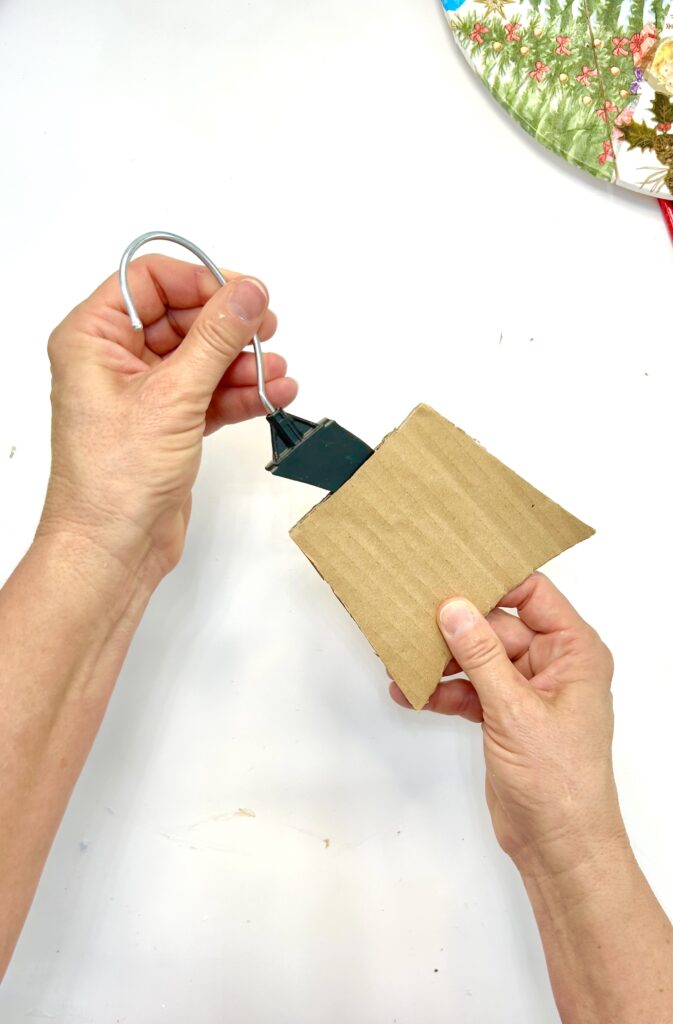 Inserting hook from a hanger into the cardboard