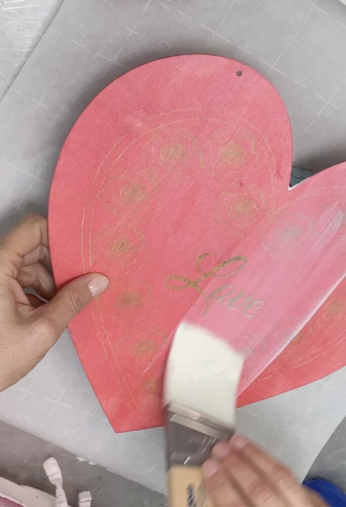 Brushing varnish on distressed heart