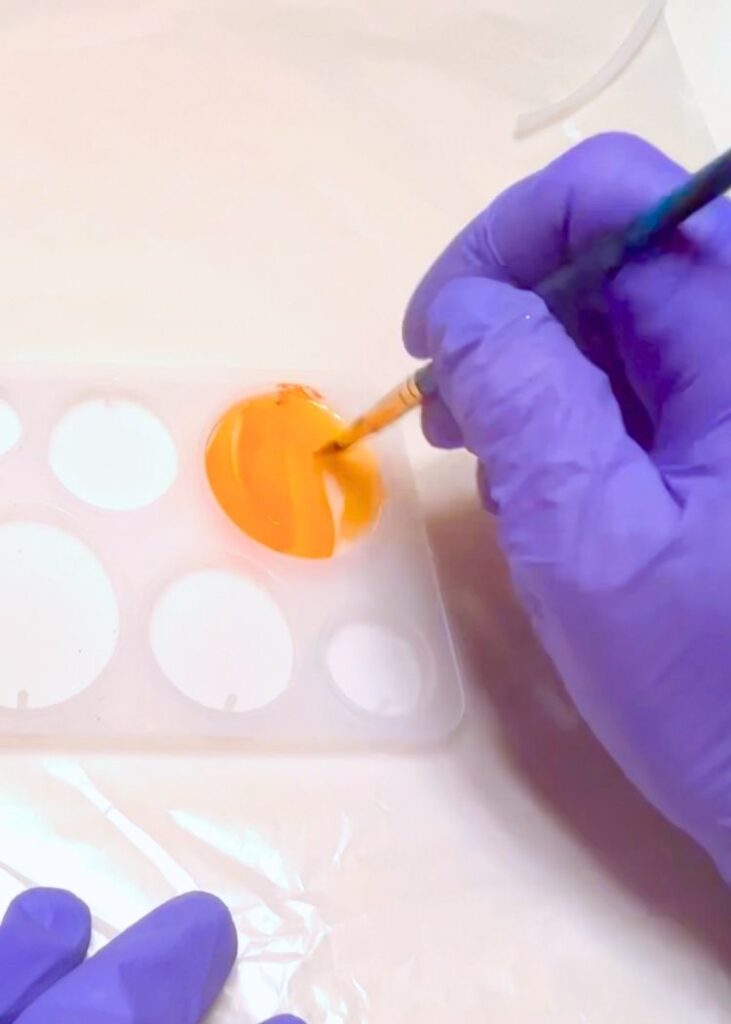 painting orange acrylic paint on the cured resin