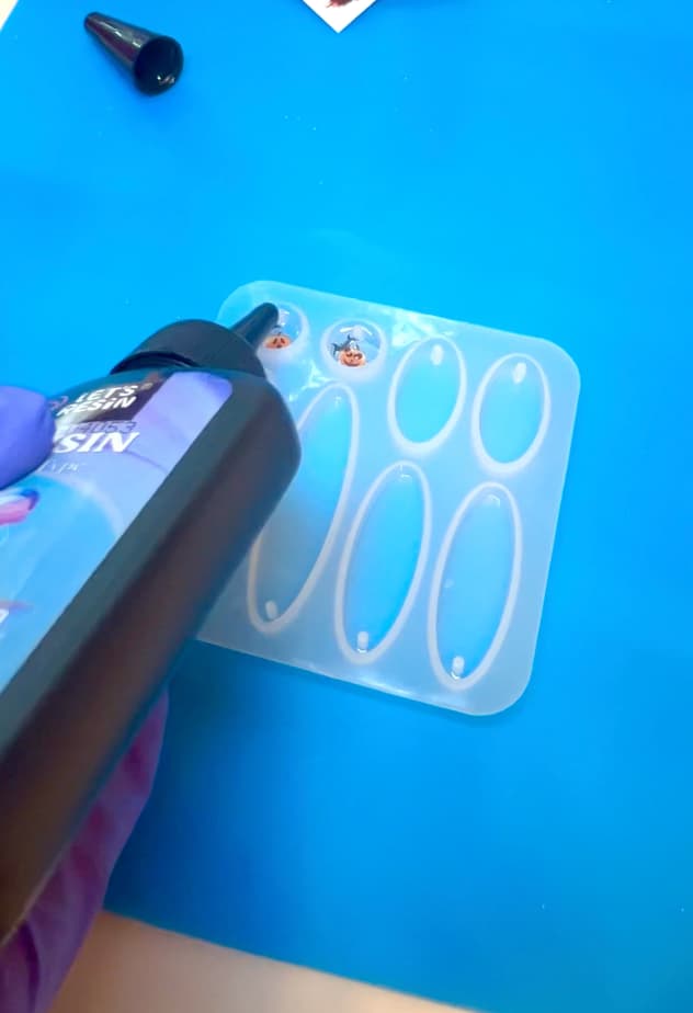 Pouring more UV resin over the nail sticker art for the earrings