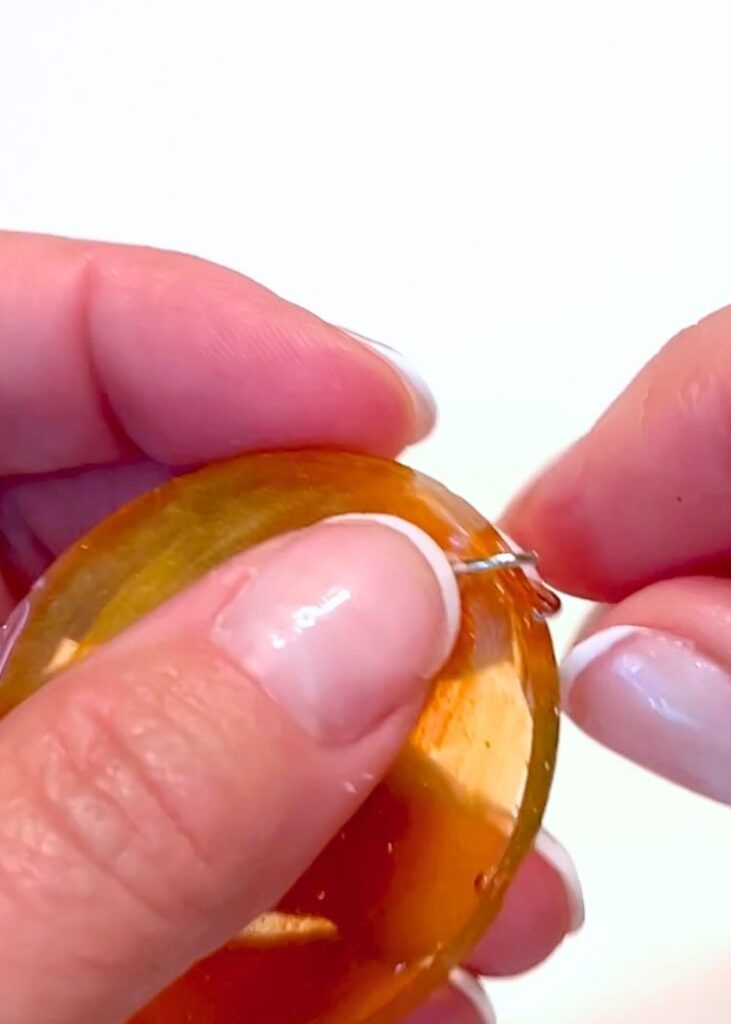 adding a jump ring to the resin pumpkin charm