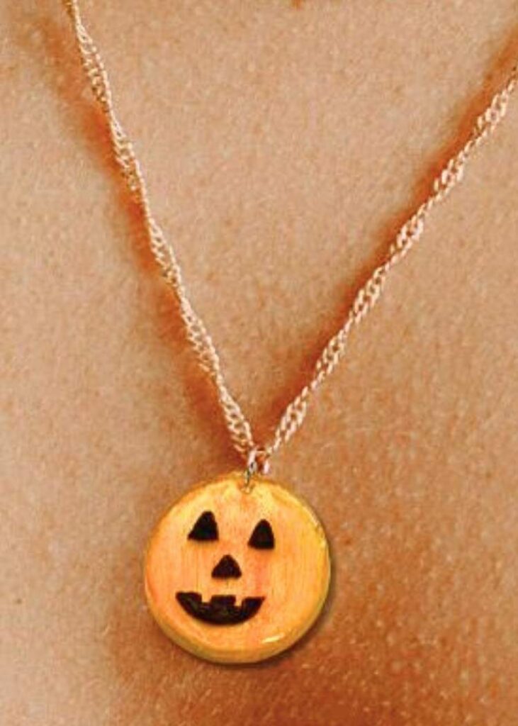 completed resin pumpkin charm, and easy UV resin jewelry project