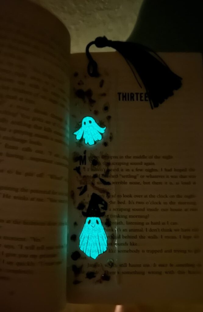 Showing how the ghost DIY bookmark for Halloween glows in the dark