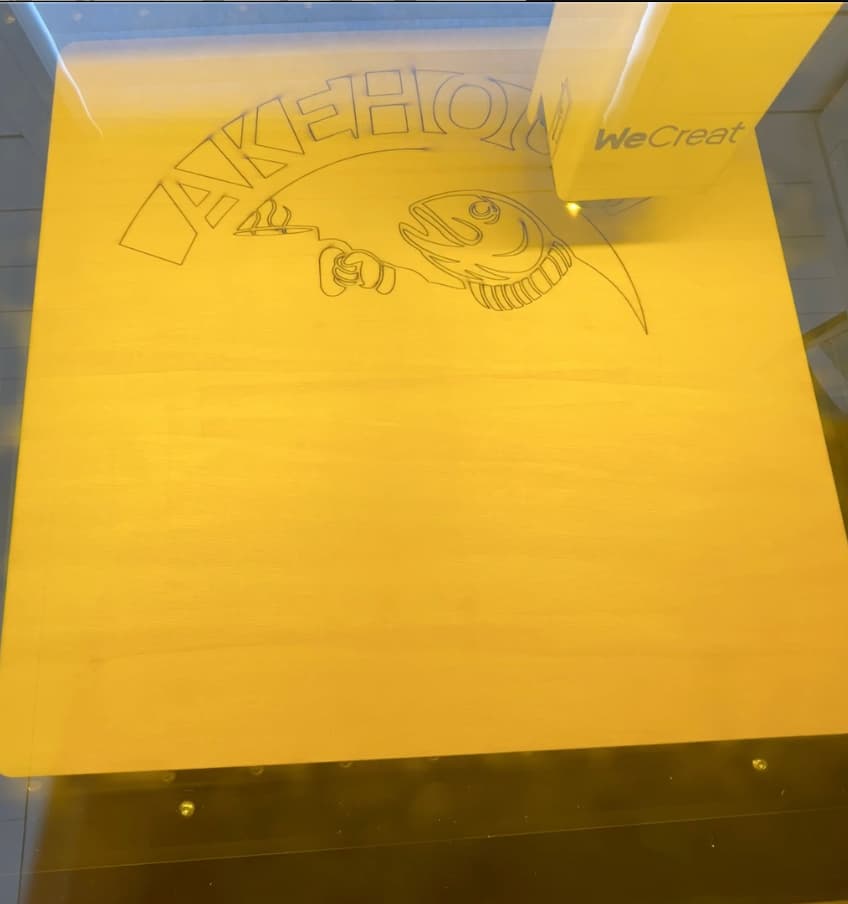 Laser engraver showing how to craft signs out of wood with a fish