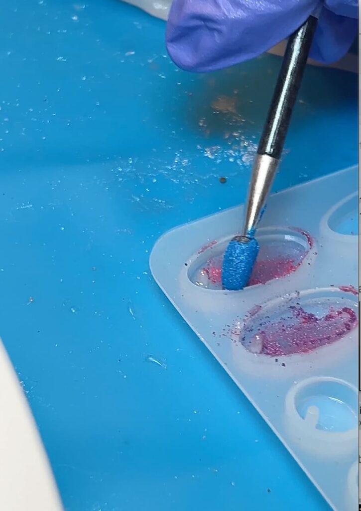 Applying pigment powder for the background of the jellyfish earrings while showing how to make jewelry