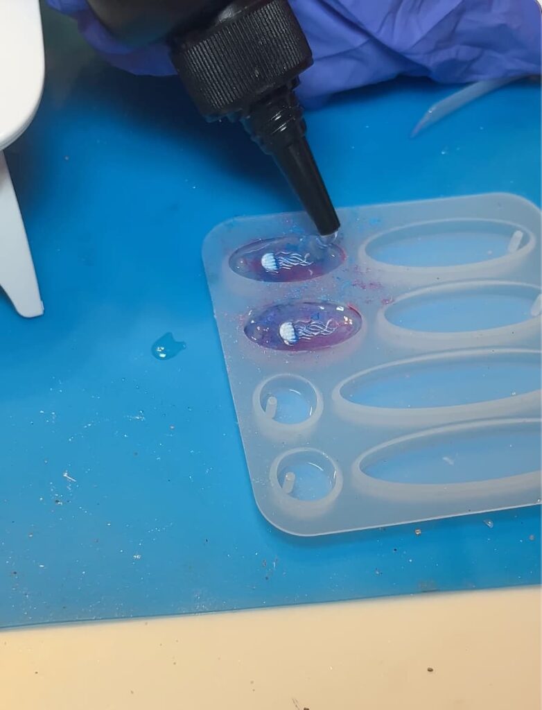 Showing how to make earrings by adding resin to a silicone mold