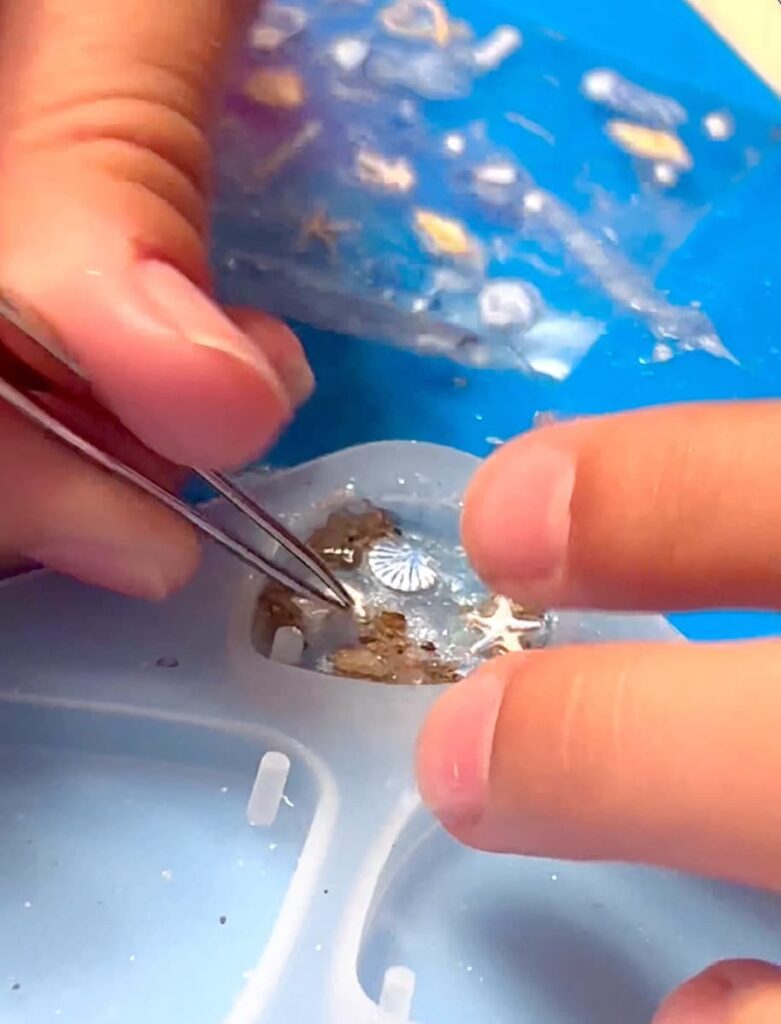 Adding beach themed nail stickers to the UV resin earrings