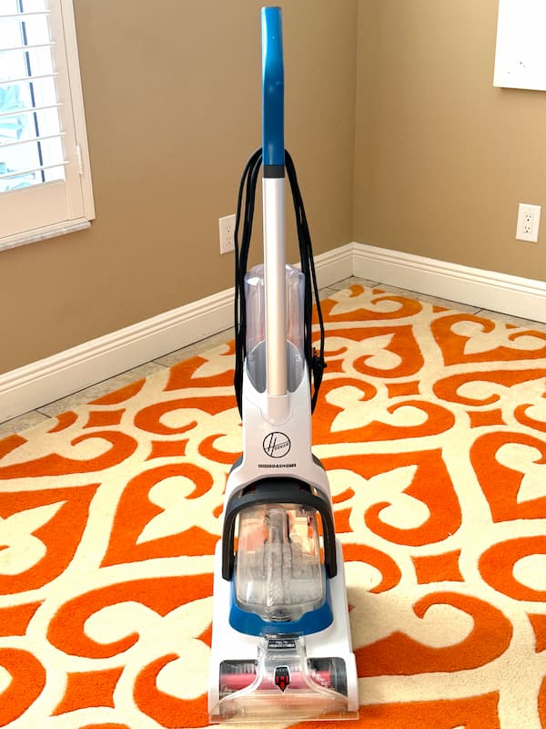 Hoover rug cleaner on orange and white rug used in showing how to clean rugs