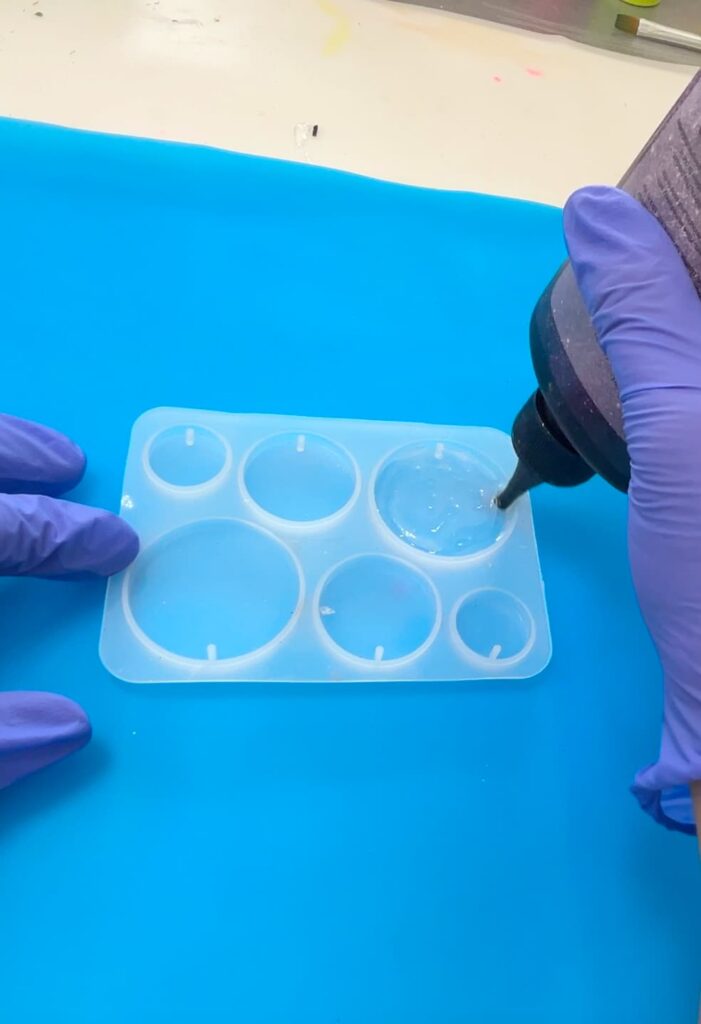 Adding the first layer of UV resin into the mold for the penguin tattoo charm DIY