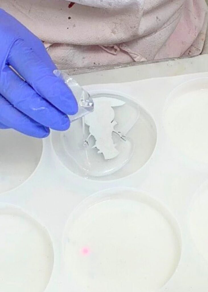 Pouring clear resin over the snowman decor cutout