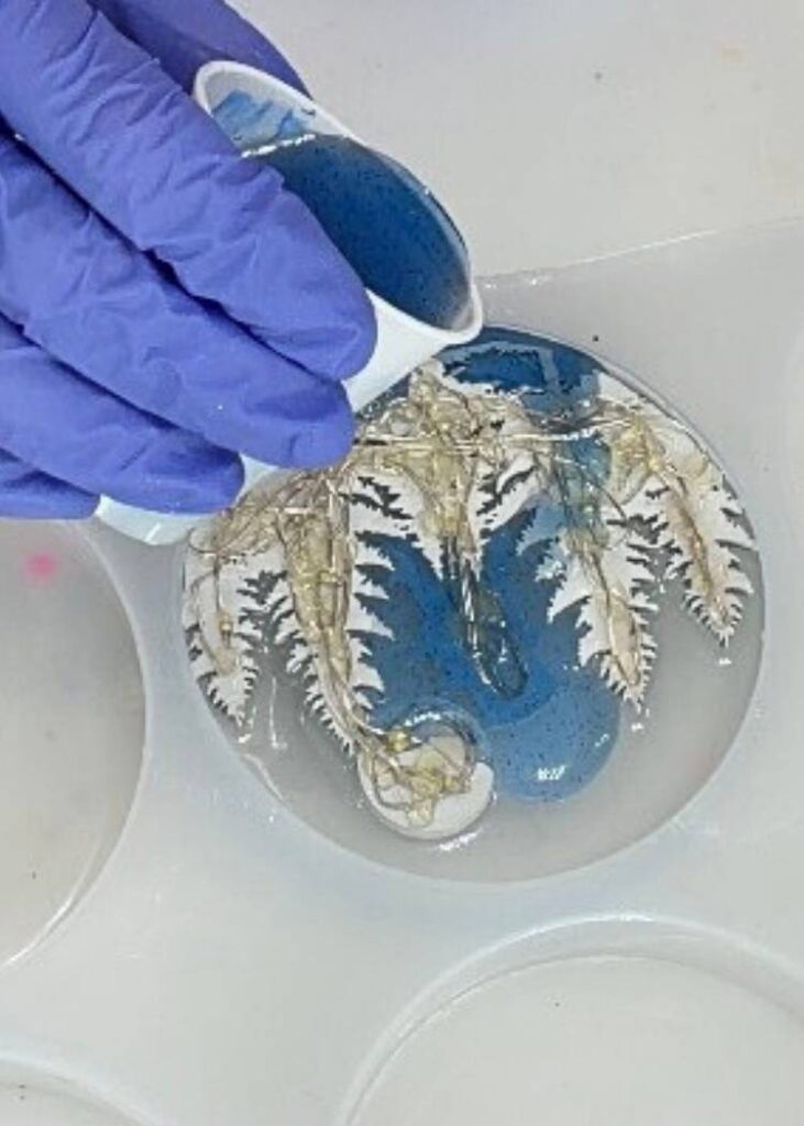 Pouring tinted blue resin over the lights and the snowman decor