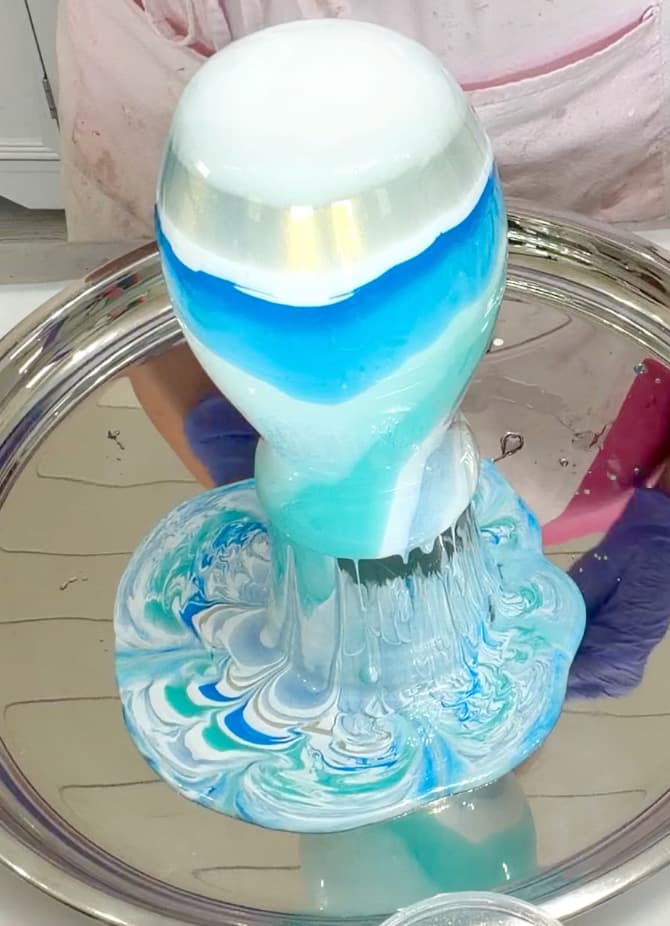 Vase dripping blue and white resin onto the siliver tray for the coastal decor