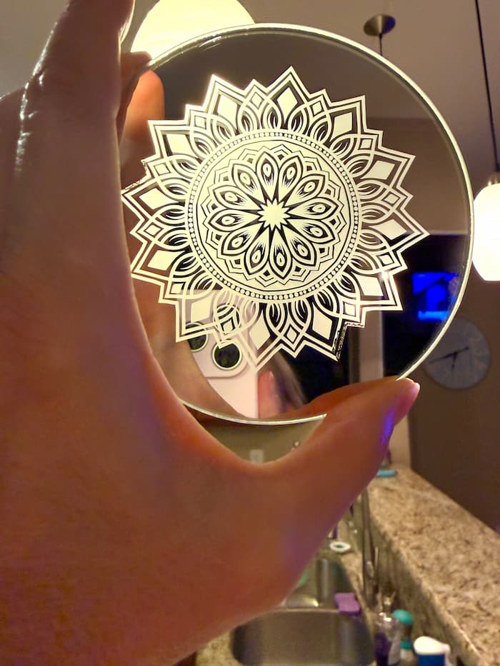 Holding the laser engraved mirror to the light and I realized I figured out how to make a nightlight