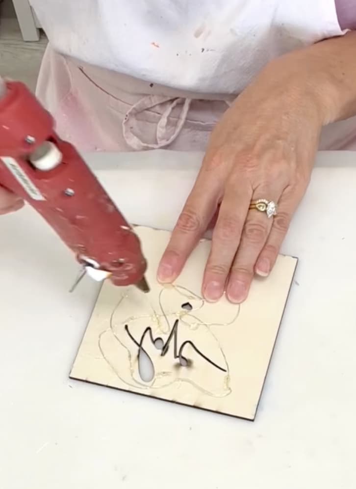 Hot gluing fairy lights as part of how to make a shadowbox