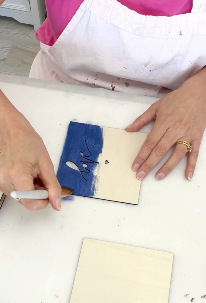 Painting the wood piece with love cut out