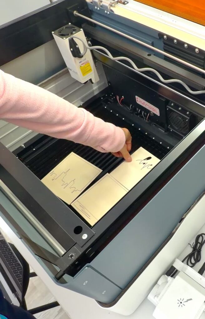 Taking the pieces of the Valentine's Day shadow box out of the laser engraver