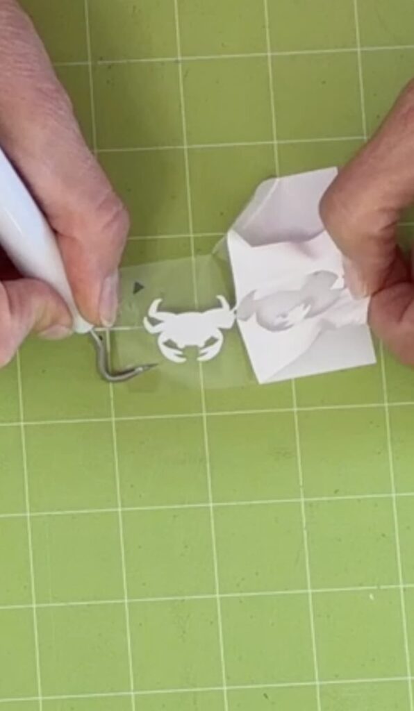Weeding the crab design on the cricut cutting mat