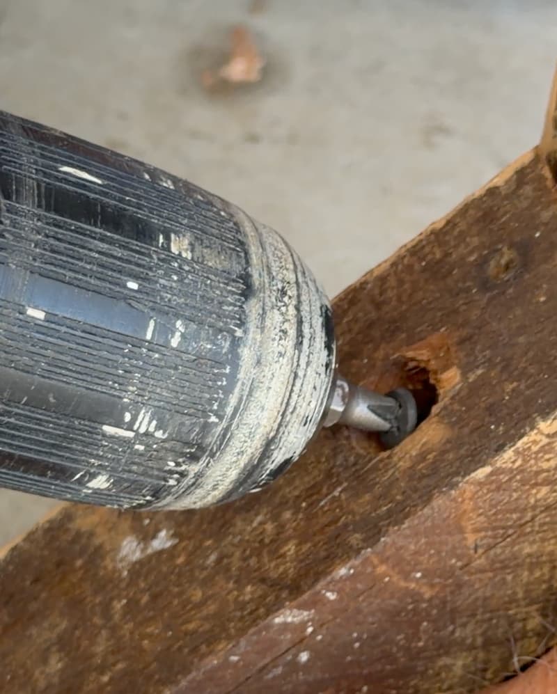 Using drill to screw the bench brackets