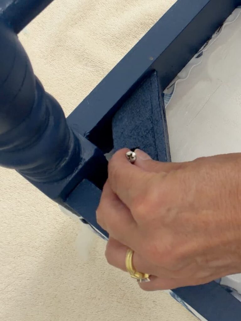 putting in a screw to reattach the cushion to the bench base