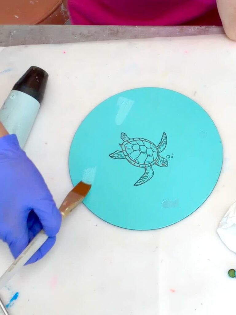 Painting the areas where the bumpers were on the dollar tree cutting board craft