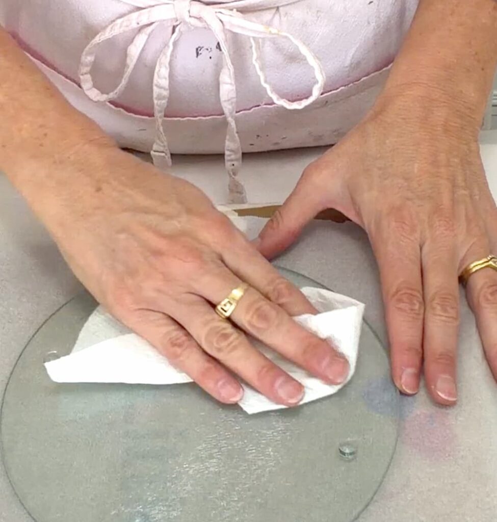 Wiping Dollar Tree glass cutting board to clean it