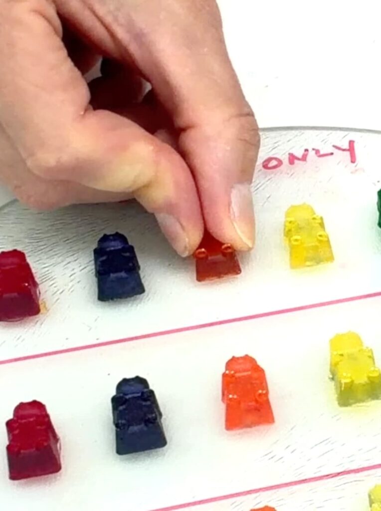 Testing the best glue for glass by using my finger and thumb to try to move the glued on gummy bear