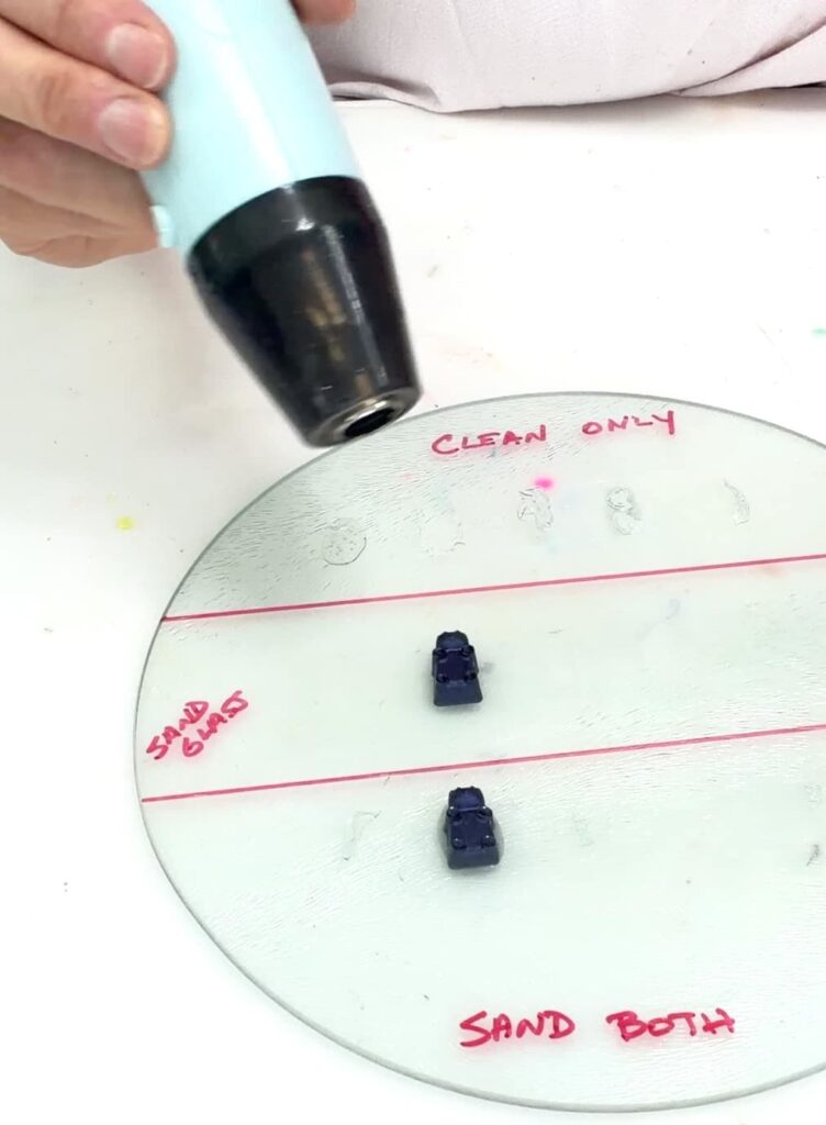 Using a heat gun to heat up a resin gummy bear to see if the glue stick to glass