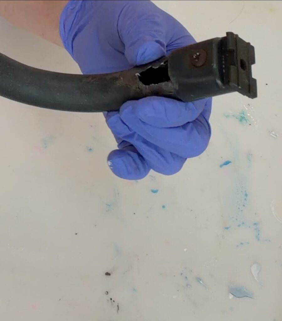 Showing the hole left in the metal after showing how to clean rust off meta