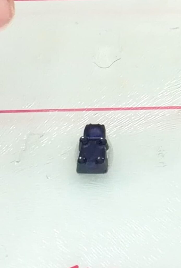One gummy bear glued to glass cutting board