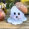DIY Ghost decoration acorn craft sitting on wood with leaves and a natural acorn
