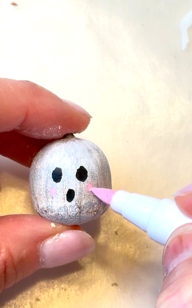 Coloring rosy cheeks on acorn ghost